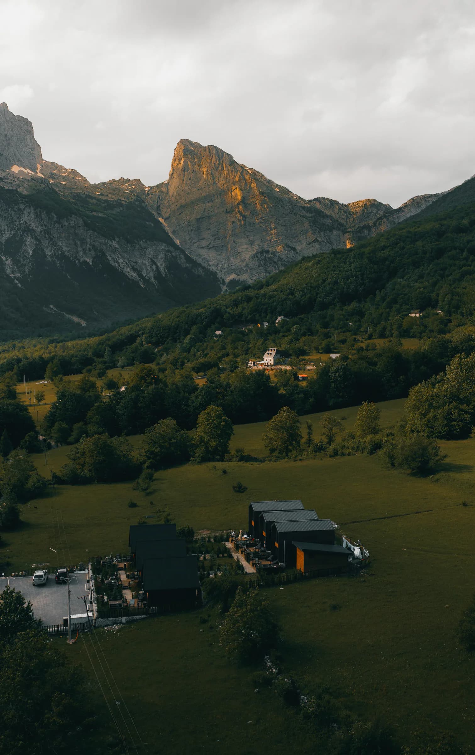 SeSam Villas beneath a dramatic mountain ridge at golden hour