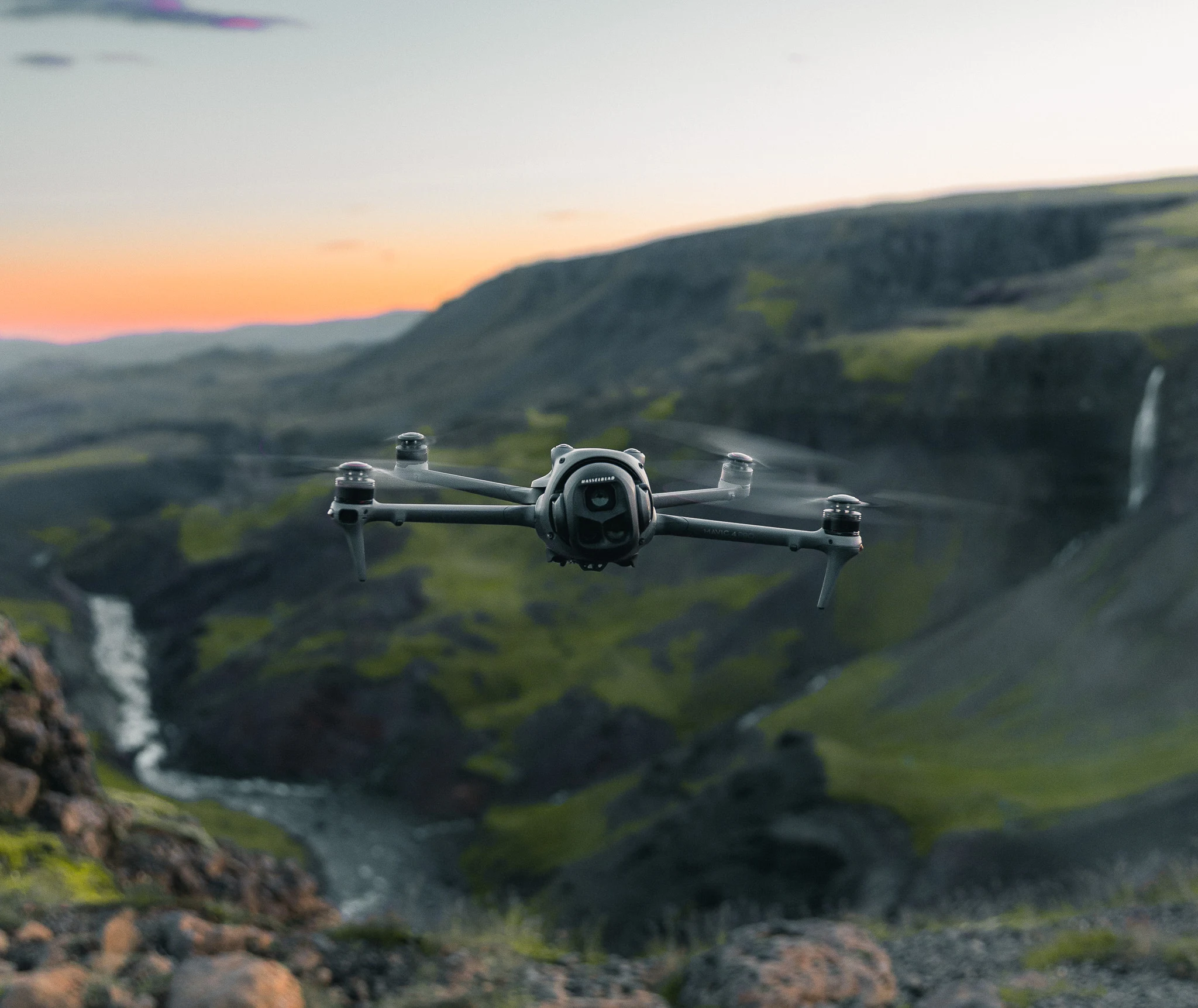 A camera drone flying through a canyon at sunset